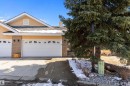 The property features a multi-car garage with white doors, a light brick facade, and an inviting entryway - 14 920 119 Street, Edmonton, AB  - Outdoor 
