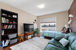 This room features hardwood flooring, a large window providing natural light, and a ceiling-mounted light fixture - 