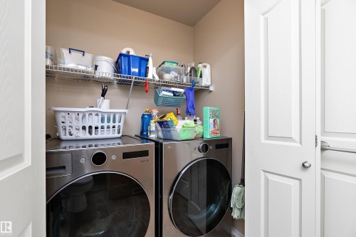 Laundry area featuring a stacked washer and dryer, and wire shelving for storage - 14 920 119 Street, Edmonton, AB - Indoor Photo Showing Laundry Room