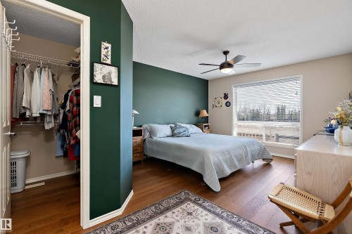 This room features hardwood flooring, a ceiling fan with integrated lighting, and a window with horizontal blinds - 14 920 119 Street, Edmonton, AB - Indoor Photo Showing Bedroom