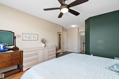 This room features a ceiling fan with integrated lighting, neutral wall colors, and hardwood flooring - 14 920 119 Street, Edmonton, AB - Indoor Photo Showing Bedroom