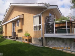 Stucco exterior with multiple windows, including a prominent half-round window - 