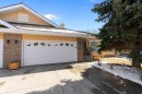The property features a spacious front driveway, a two-car garage with decorative window inserts, and a covered entry with steps - 14 920 119 Street, Edmonton, AB  - Outdoor 