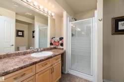 Bathroom featuring a vanity with a countertop, a single sink, and light wood cabinetry - 