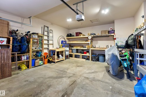 The property includes a spacious garage with a concrete floor, overhead lighting, and an automatic garage door opener - 14 920 119 Street, Edmonton, AB - Indoor Photo Showing Garage