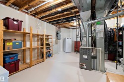 The property features an unfinished basement with exposed ceiling joists and ductwork, a white water heater, and a furnace - 