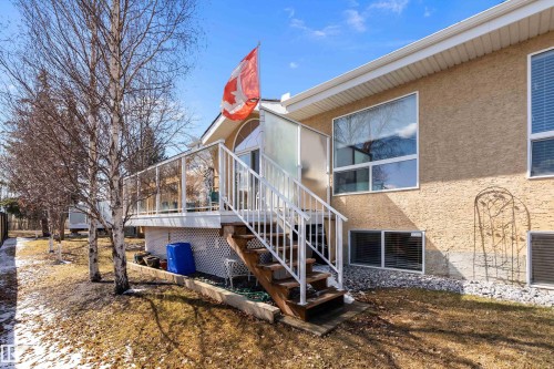 The property features a raised deck with glass panel railing and white stairs, providing outdoor space - 14 920 119 Street, Edmonton, AB - Outdoor