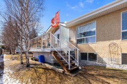 The property features a raised deck with glass panel railing and white stairs, providing outdoor space - 