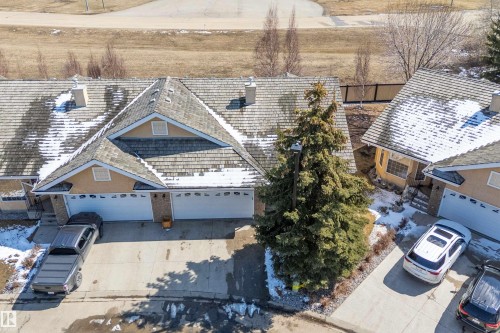 This property features a multi-gabled roofline and an attached garage with two overhead doors - 14 920 119 Street, Edmonton, AB - Outdoor