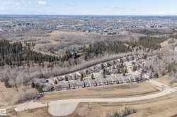 Aerial view of the community, showcasing surrounding wooded areas and residential properties - 