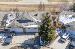 This property features a multi-gabled roofline and an attached garage with two overhead doors - 