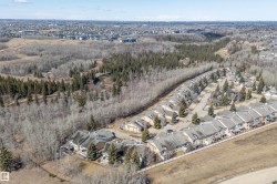 Aerial view of the property's community, featuring townhouses with private decks, surrounded by mature trees and natural landscapes - 