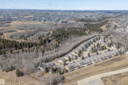 Aerial view showcasing the property within a community of residences, bordered by expansive natural wooded areas - 