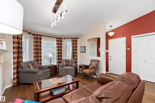 The living area features hardwood floors and a bay window - 14 920 119 Street, Edmonton, AB - Indoor Photo Showing Living Room With Fireplace
