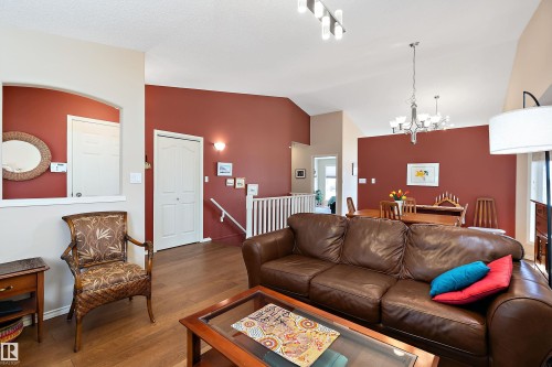 Living area featuring hardwood floors, a vaulted ceiling, and a chandelier in the dining space - 14 920 119 Street, Edmonton, AB - Indoor Photo Showing Living Room