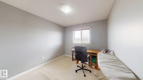 This room features light-colored walls and carpeting, with a window providing natural light - 5929 8 Avenue, Edmonton, AB - Indoor Photo Showing Office