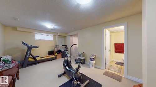 Spacious room with light-colored carpeting, recessed lighting, and a window - 5929 8 Avenue, Edmonton, AB - Indoor Photo Showing Gym Room