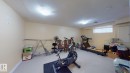 The property features an extensive room with light-colored walls and carpeting, offering a versatile space - 5929 8 Avenue, Edmonton, AB  - Indoor Photo Showing Gym Room 