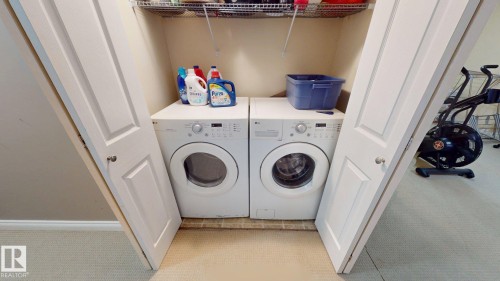 Convenient laundry area featuring a front-loading washing machine and dryer, along with a wire rack for additional storage - 5929 8 Avenue, Edmonton, AB - Indoor Photo Showing Laundry Room