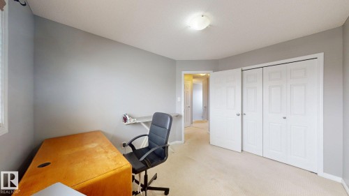 This room features neutral-toned walls, carpeted flooring, and a ceiling light fixture - 5929 8 Avenue, Edmonton, AB - Indoor Photo Showing Other Room