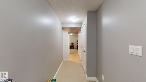 Hallway with light-colored carpeting, white baseboards, and neutral-toned walls - 5929 8 Avenue, Edmonton, AB - Indoor Photo Showing Other Room