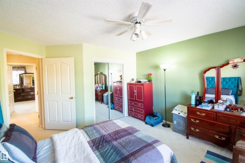 This room features a ceiling fan, light-colored carpeting, and a wall with a green accent - 2 9703 174 Street, Edmonton, AB - Indoor Photo Showing Bedroom