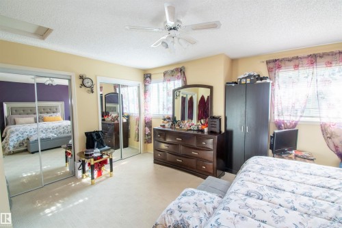 This room features light-colored walls and carpeting, with two windows providing natural illumination - 2 9703 174 Street, Edmonton, AB - Indoor Photo Showing Bedroom