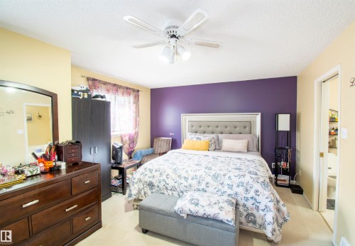 The bedroom features a ceiling fan, a window with curtains, and a doorway leading to another room - 2 9703 174 Street, Edmonton, AB - Indoor Photo Showing Bedroom