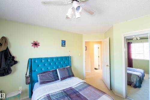 This room features light green walls and a ceiling fan with integrated lighting - 2 9703 174 Street, Edmonton, AB - Indoor Photo Showing Bedroom