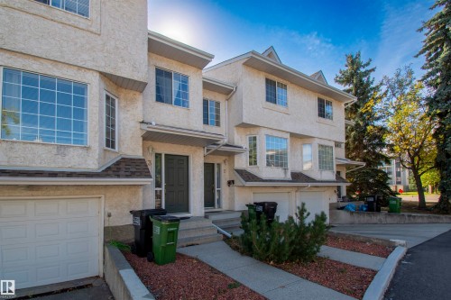 The property features a multi-story exterior with textured stucco siding and multiple windows, providing natural light - 2 9703 174 Street, Edmonton, AB - Outdoor With Facade