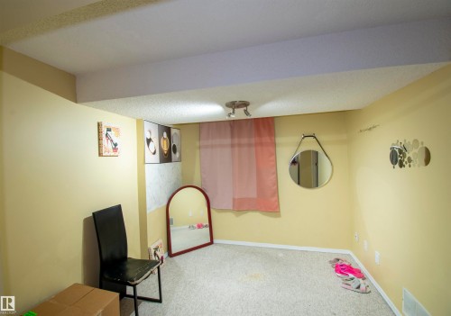 This room features light yellow walls, a light-colored carpet, and a white ceiling with a track light fixture - 2 9703 174 Street, Edmonton, AB - Indoor Photo Showing Other Room