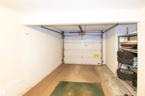 The property features a garage with a white sectional door and concrete flooring - 2 9703 174 Street, Edmonton, AB - Indoor Photo Showing Garage