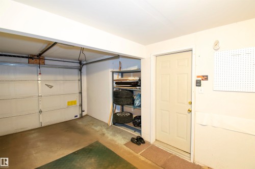 The property features an attached garage with a sectional garage door and an interior access door - 2 9703 174 Street, Edmonton, AB - Indoor Photo Showing Garage