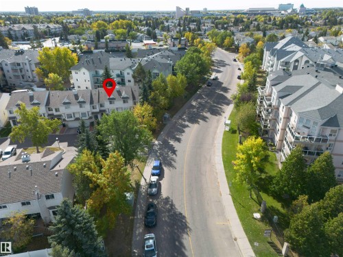 Aerial view showcasing the property within a neighborhood featuring mature trees and nearby apartment buildings - 2 9703 174 Street, Edmonton, AB - Outdoor With View
