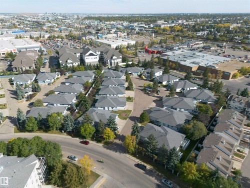 Aerial view showcasing the residential properties within a developed neighborhood, featuring a mix of detached homes and townhouses with grey roofs - 2 9703 174 Street, Edmonton, AB - Outdoor With View