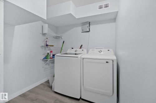 Laundry area with a washer and dryer, white wire shelving, and light wood-style flooring - 12002 37 Street, Edmonton, AB - Indoor Photo Showing Laundry Room