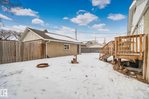 The property features a detached garage with a side-gabled roof and a wooden fence - 12002 37 Street, Edmonton, AB - Outdoor