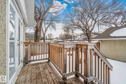 The property features a wooden deck with railing and a set of stairs - 12002 37 Street, Edmonton, AB - Outdoor
