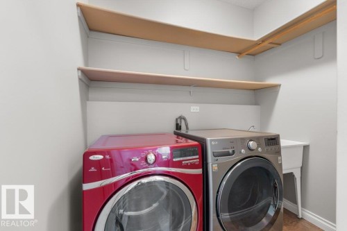 Laundry area featuring light-colored walls, built-in shelving, and a utility sink - 16419 53 Street, Edmonton, AB - Indoor Photo Showing Laundry Room