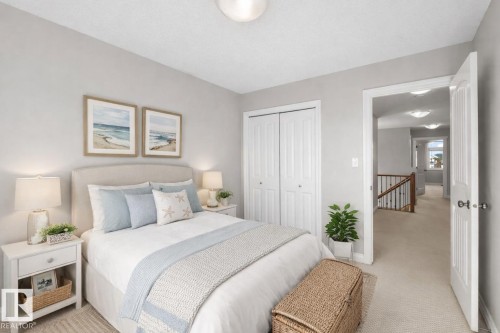This room features light-colored walls and carpeting, a ceiling light fixture, and bifold closet doors - 16419 53 Street, Edmonton, AB - Indoor Photo Showing Bedroom