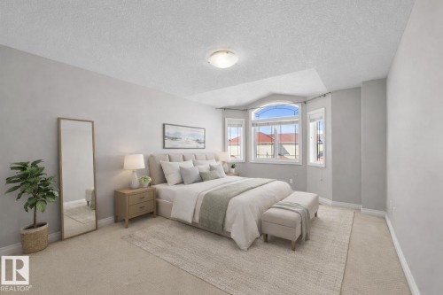 Bright bedroom featuring a large bay window, carpeted flooring, and light-colored walls - 16419 53 Street, Edmonton, AB - Indoor Photo Showing Bedroom