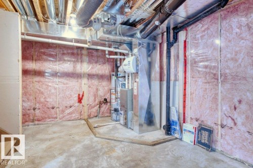 Unfinished basement area with exposed insulation, concrete flooring, and visible ductwork - 16419 53 Street, Edmonton, AB - Indoor Photo Showing Basement