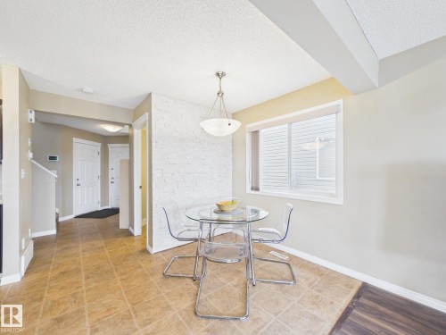 Dining area featuring a window, overhead light fixture, and tile flooring - 9073 Scott Crescent, Edmonton, AB - Indoor Photo Showing Dining Room