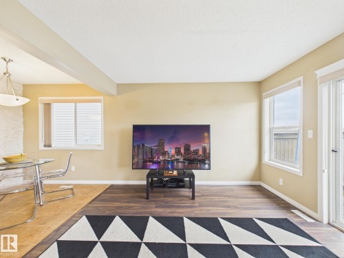 The living area features wood-look flooring and a large window providing natural light - 9073 Scott Crescent, Edmonton, AB - Indoor