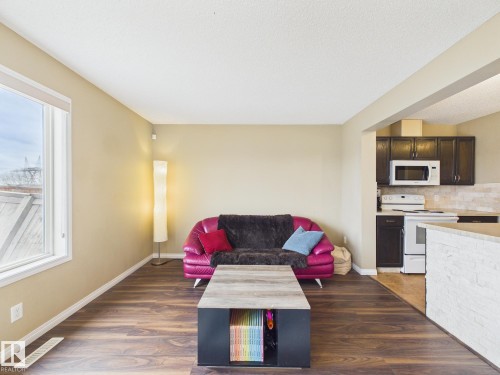 The living area features wood-look flooring and a window providing natural light - 9073 Scott Crescent, Edmonton, AB - Indoor Photo Showing Kitchen