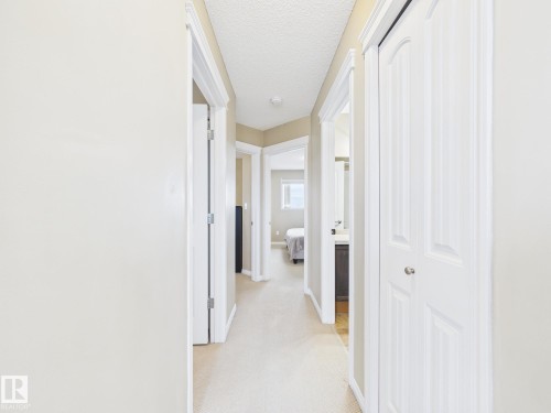 This hallway features light-colored walls and carpeted flooring - 9073 Scott Crescent, Edmonton, AB - Indoor Photo Showing Other Room