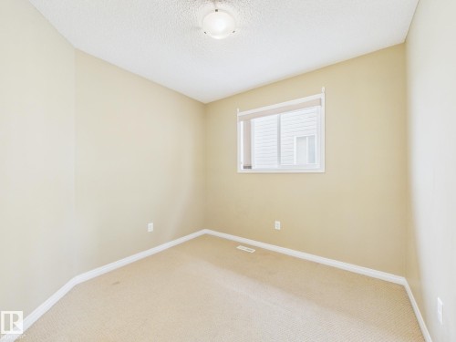 This space features neutral-toned walls, carpeted flooring, and a window with a roller blind - 9073 Scott Crescent, Edmonton, AB - Indoor Photo Showing Other Room