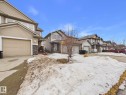 The property features a beige exterior with stone accents, a beige garage door, and a paved driveway - 9073 Scott Crescent, Edmonton, AB  - Outdoor 