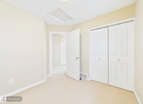 This room features neutral-toned walls, carpeted flooring, and white bi-fold closet doors - 9073 Scott Crescent, Edmonton, AB - Indoor Photo Showing Other Room