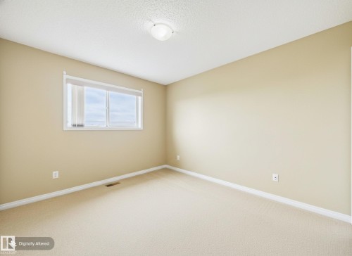 This room features neutral-toned walls, a window with blinds, and light-colored carpet flooring, providing a versatile foundation - 9073 Scott Crescent, Edmonton, AB - Indoor Photo Showing Other Room